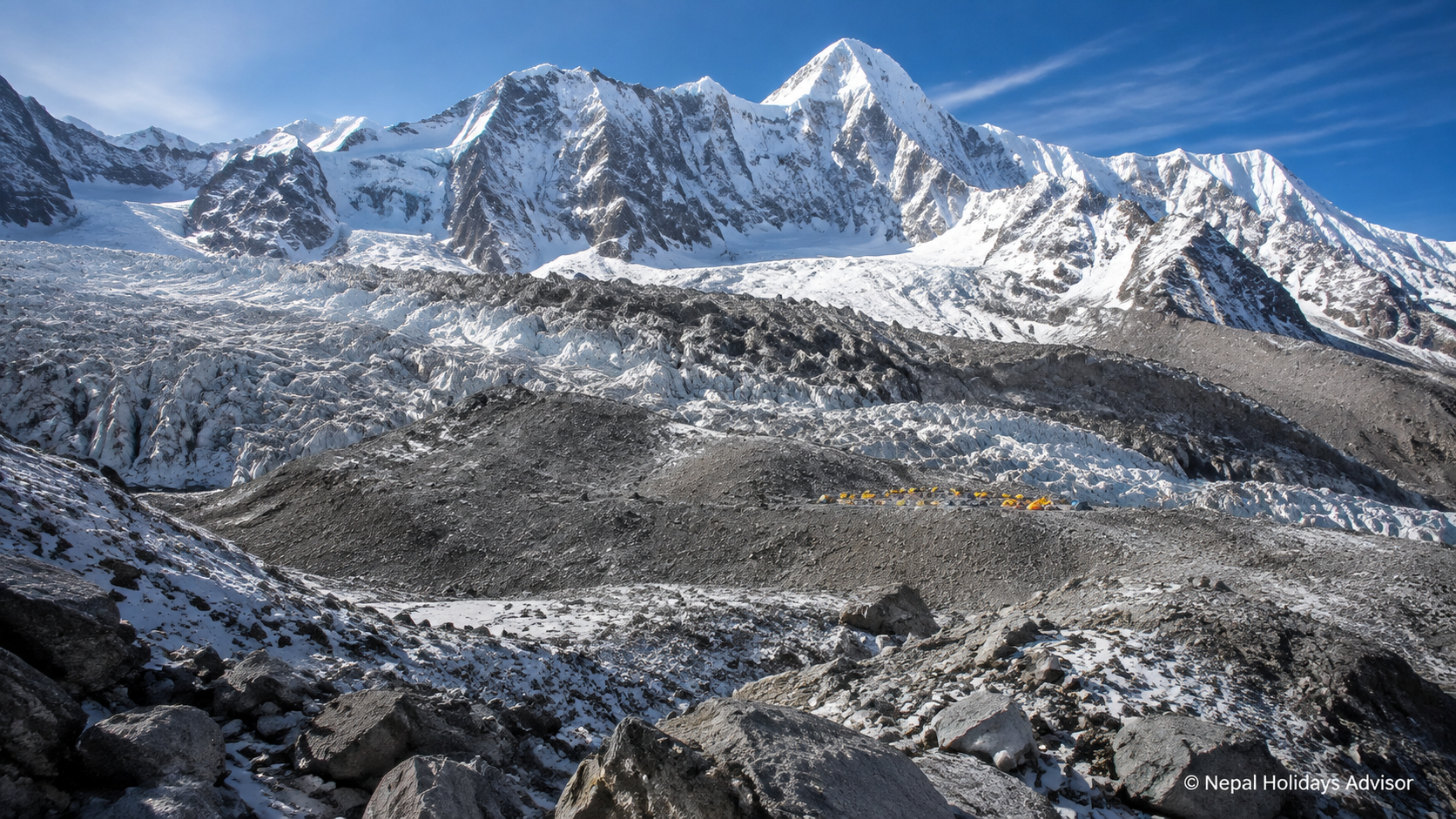 Small yellow and orange expedition tents stand beside a glacier beneath towering snow-covered mountain walls.